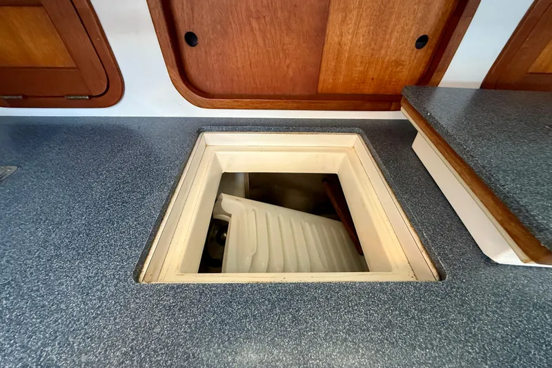 St. Elmo's Fire II Yacht Photos Pics Boat interior with open hatch, revealing storage compartment, Legacy 40, 1999 model.