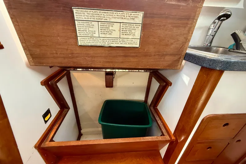 St. Elmo's Fire II Yacht Photos Pics 1999 Legacy 40 yacht interior with wooden cabinetry and green waste bin.