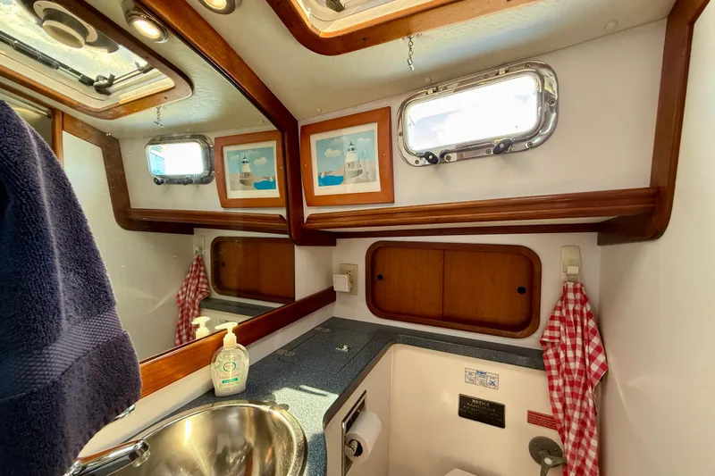 St. Elmo's Fire II Yacht Photos Pics 1999 Legacy 40 yacht bathroom with sink, mirror, and nautical decor.