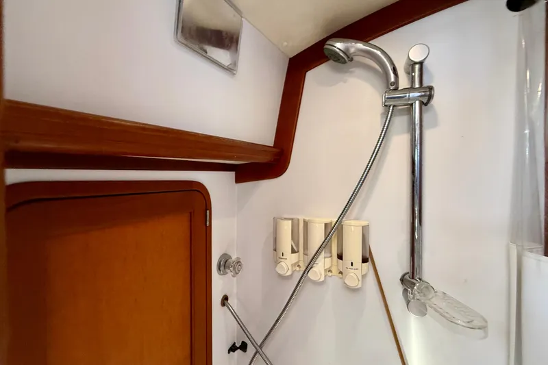 St. Elmo's Fire II Yacht Photos Pics Shower area in 1999 Legacy 40 boat with wooden accents and soap dispensers.