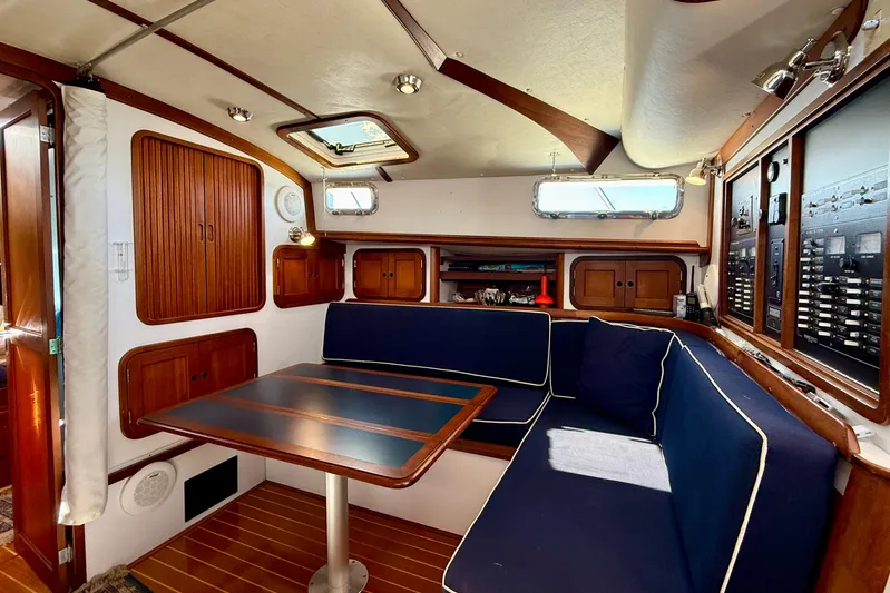 St. Elmo's Fire II Yacht Photos Pics Cozy interior of 1999 Legacy 40 yacht with wooden cabinetry and blue seating.