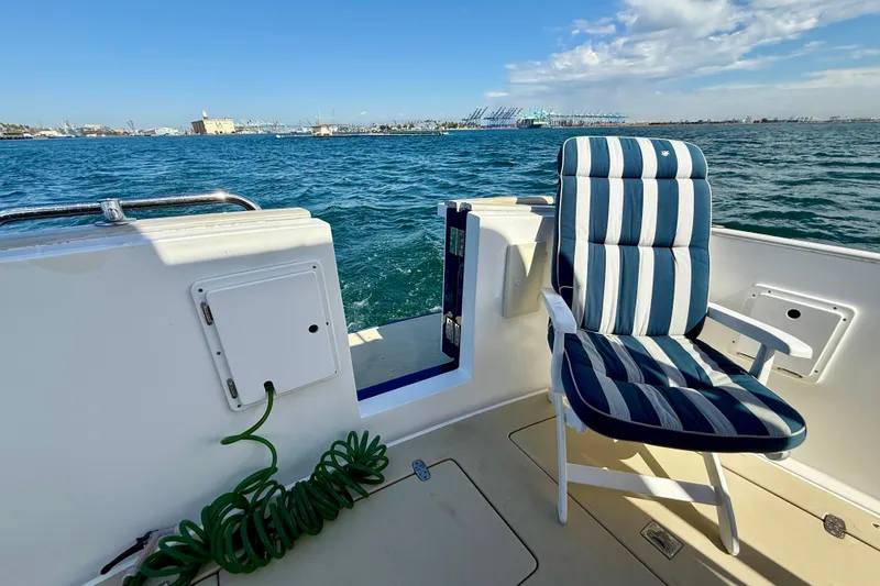 St. Elmo's Fire II Yacht Photos Pics Deck view of 1999 Legacy 40 boat with striped chair and ocean backdrop.