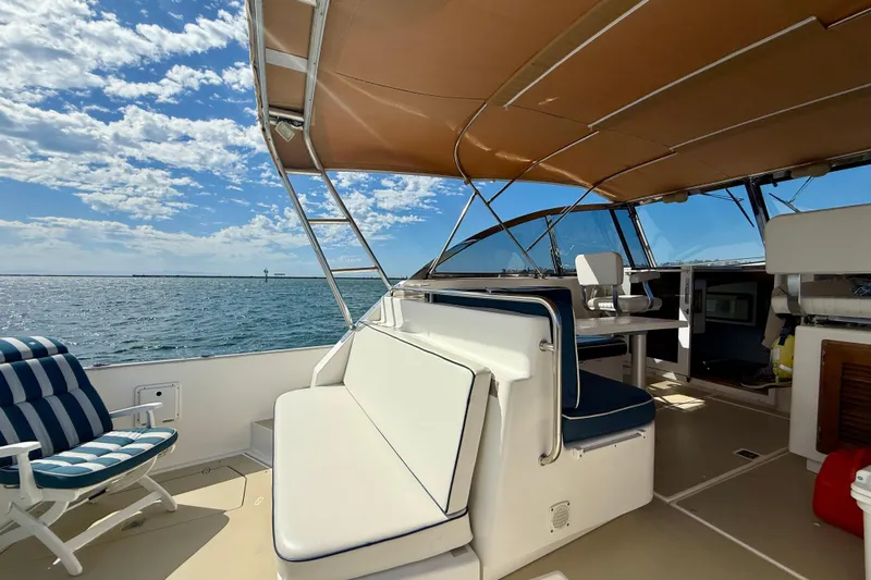 St. Elmo's Fire II Yacht Photos Pics Spacious deck of 1999 Legacy 40 yacht with seating, under a sunny sky.