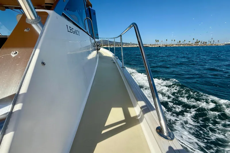 St. Elmo's Fire II Yacht Photos Pics 1999 Legacy 40 boat cruising on blue ocean near coastline.