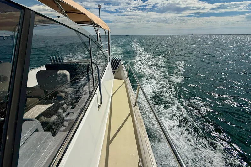 St. Elmo's Fire II Yacht Photos Pics Legacy 40 boat cruising on open sea, leaving a wake behind, under a partly cloudy sky.