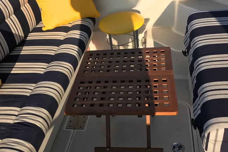 Tranquility Yacht Photos Pics Interior of 2008 Back Cove 33 Hard Top Express with striped seating and wooden table.