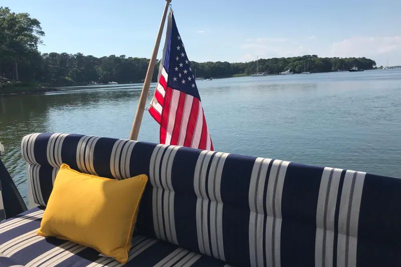 Tranquility Yacht Photos Pics 2008 Back Cove 33 Hard Top Express with striped seating, yellow pillow, and American flag on calm water.