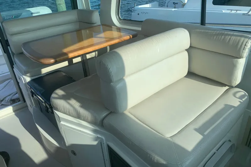 Tranquility Yacht Photos Pics 2008 Back Cove 33 Hard Top Express interior with cushioned seating and wooden table.