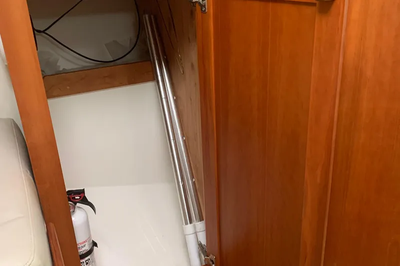 Tranquility Yacht Photos Pics 2008 Back Cove 33 Hard Top Express interior storage with fire extinguisher and metal pole.
