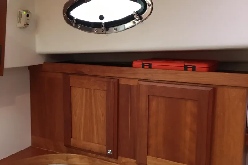 Tranquility Yacht Photos Pics 2008 Back Cove 33 Hard Top Express interior with wooden cabinets and porthole window.