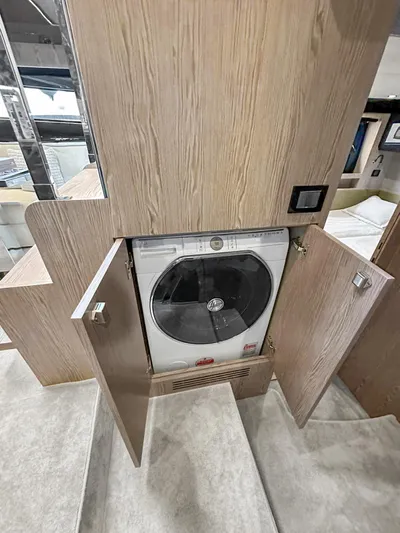  Yacht Photos Pics 2022 Azimut Atlantis 51 yacht interior with built-in washer-dryer unit.