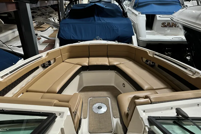  Yacht Photos Pics 2020 Sea Ray SLX 310 boat interior with tan seating and covered boats in background.