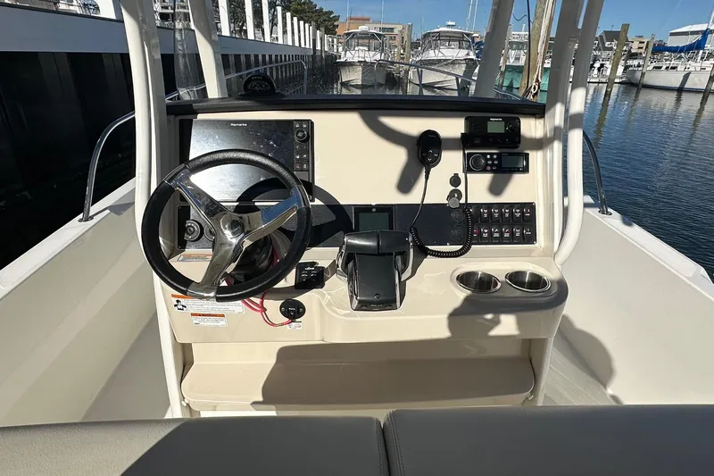 Bae Life Yacht Photos Pics 2022 Boston Whaler 270 Dauntless helm with steering wheel and navigation controls.