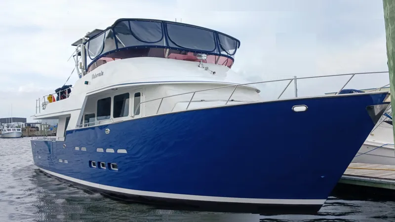  Yacht Photos Pics 2002 Kristen Yachts Pilothouse Explorer 52, blue hull, docked in a marina.