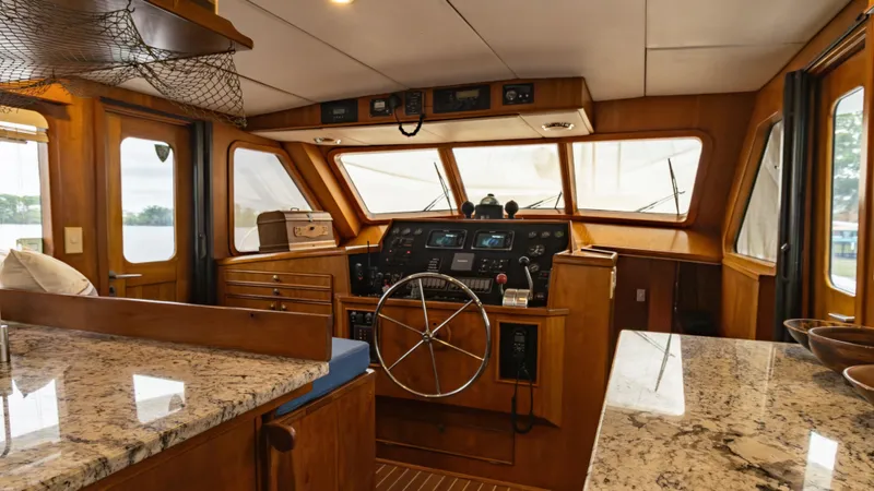  Yacht Photos Pics Pilothouse interior of 2002 Kristen Yachts Pilothouse Explorer 52 with wooden finishes and navigation controls.