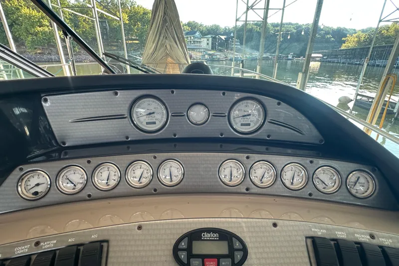  Yacht Photos Pics 2006 Four Winns 378 Vista boat dashboard with gauges and controls, docked by a scenic lake.