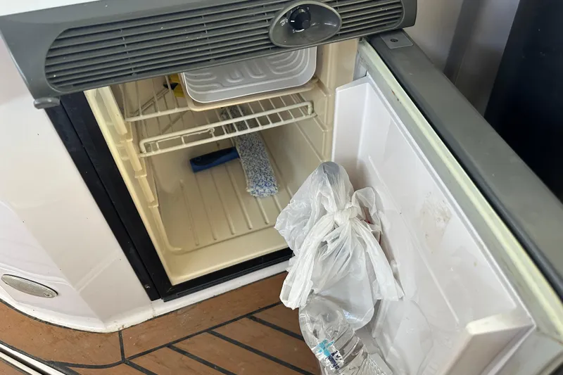  Yacht Photos Pics Open mini fridge on 2006 Four Winns 378 Vista boat, containing plastic bags and a water bottle.