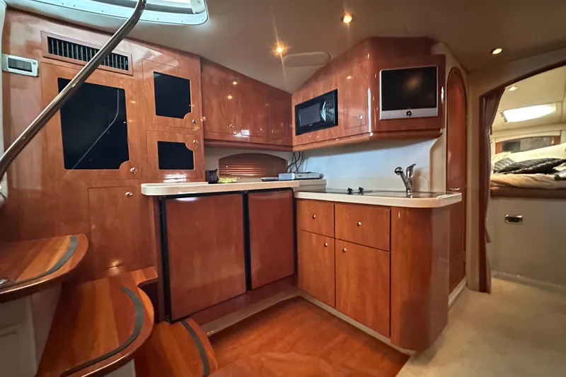  Yacht Photos Pics Luxurious 2006 Four Winns 378 Vista yacht interior with modern kitchen and wood cabinetry.