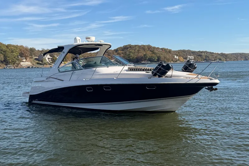  Yacht Photos Pics 2006 Four Winns 378 Vista boat on a serene lake with wooded shoreline.