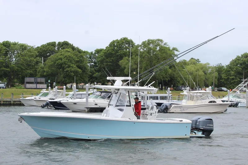 Dojo Yacht Photos Pics 2020 Regulator 28 boat cruising near marina with trees in background.
