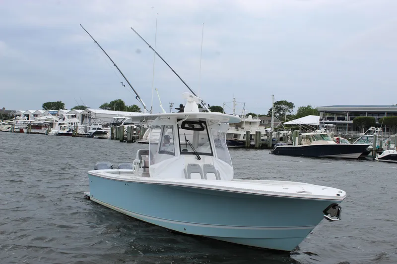 Dojo Yacht Photos Pics 2020 Regulator 28 boat docked in a marina with fishing rods.