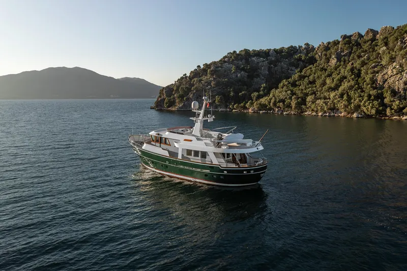 Yosma Yacht Photos Pics Luxurious 2013 Motor Yacht 71' cruising near scenic coastline at sunset.