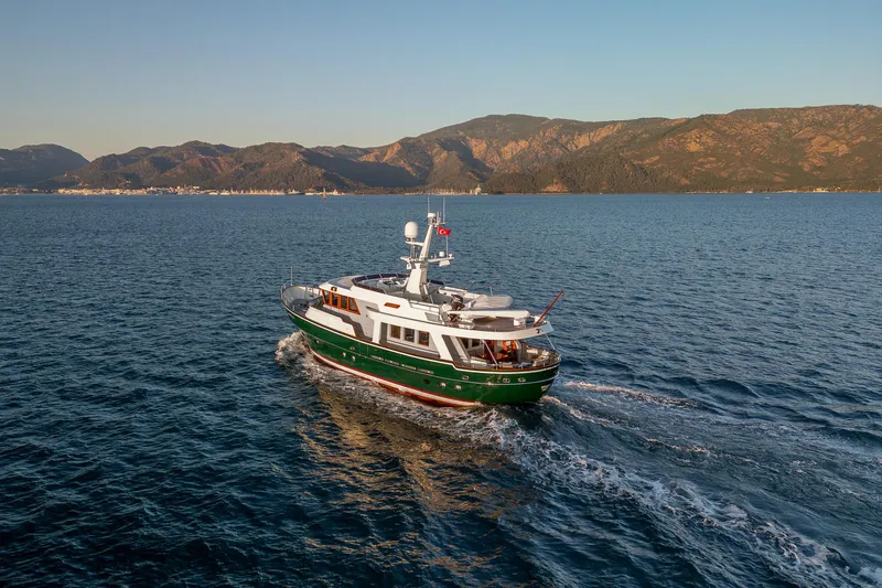 Yosma Yacht Photos Pics Luxurious 2013 Motor Yacht 71' cruising on serene waters with scenic mountain backdrop.