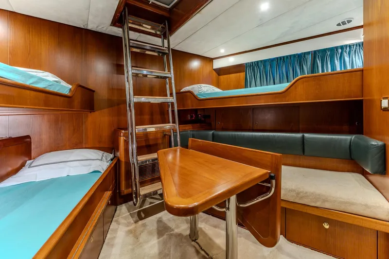Yosma Yacht Photos Pics Interior of 2013 Motor Yacht, 71', featuring wooden bunk beds and a compact seating area.