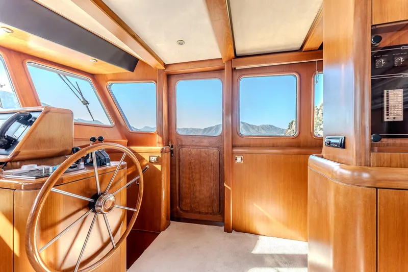 Yosma Yacht Photos Pics Interior of a 2013 Motor Yacht 71', featuring a wooden helm and panoramic windows.