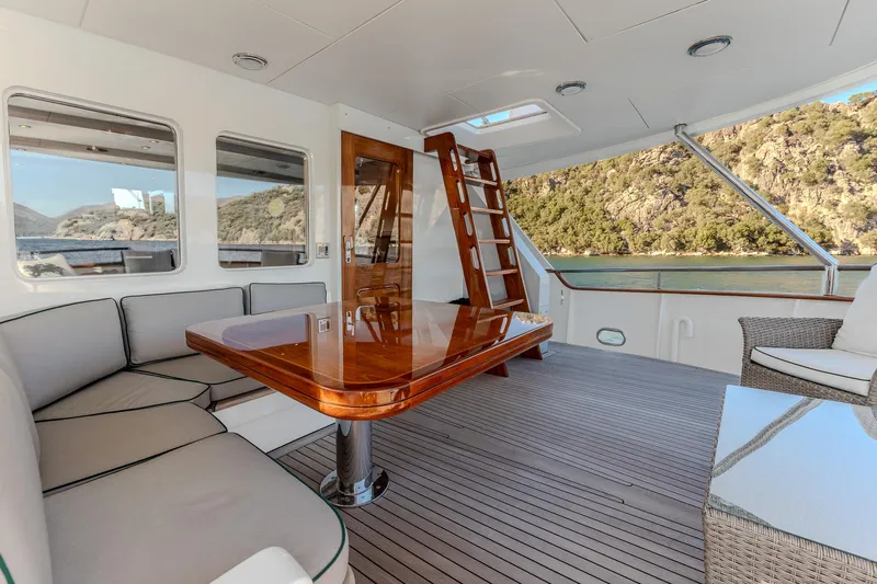 Yosma Yacht Photos Pics Luxurious 2013 Motor Yacht interior with elegant seating and wooden table, overlooking scenic waters.
