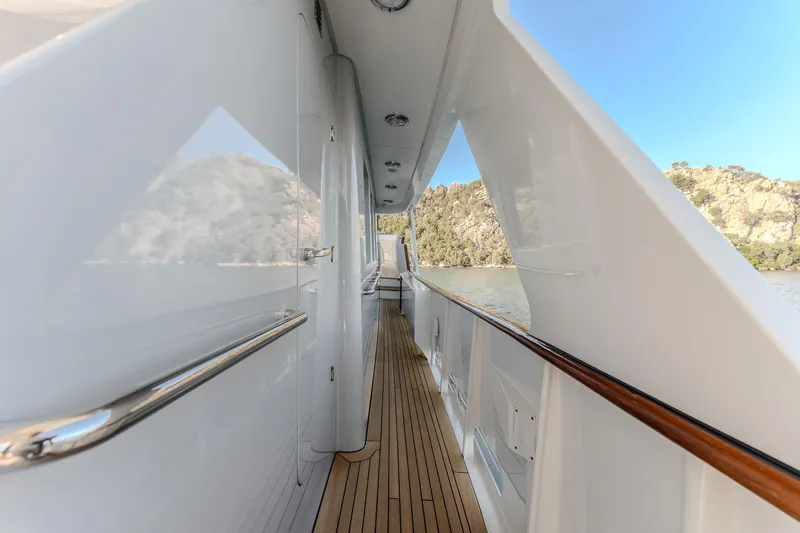 Yosma Yacht Photos Pics Side deck view of a 2013 71' Motor Yacht with sleek design and wooden flooring.