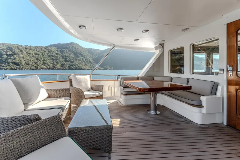 Yosma Yacht Photos Pics Luxurious 2013 Motor Yacht 71' deck with elegant seating, scenic water view.