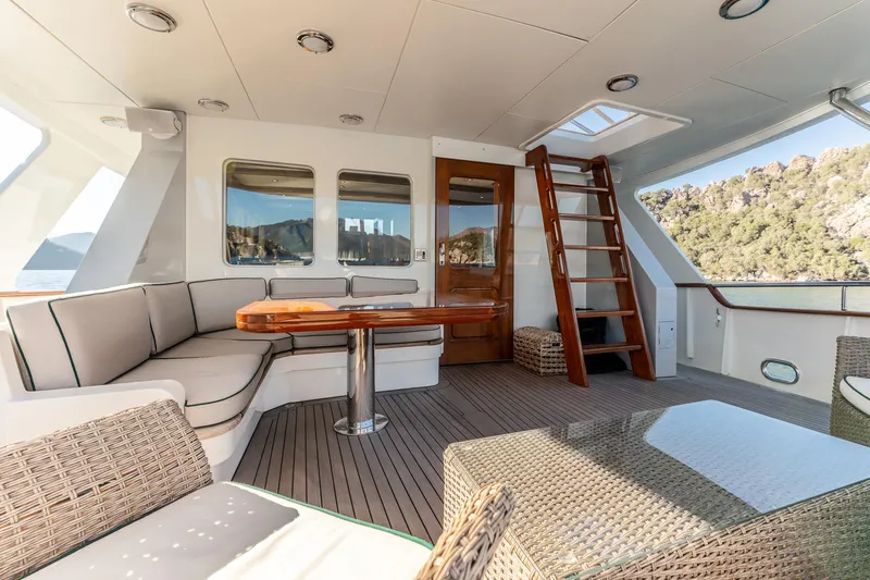 Yosma Yacht Photos Pics Luxurious 2013 Motor Yacht interior with seating, wooden table, and scenic views.