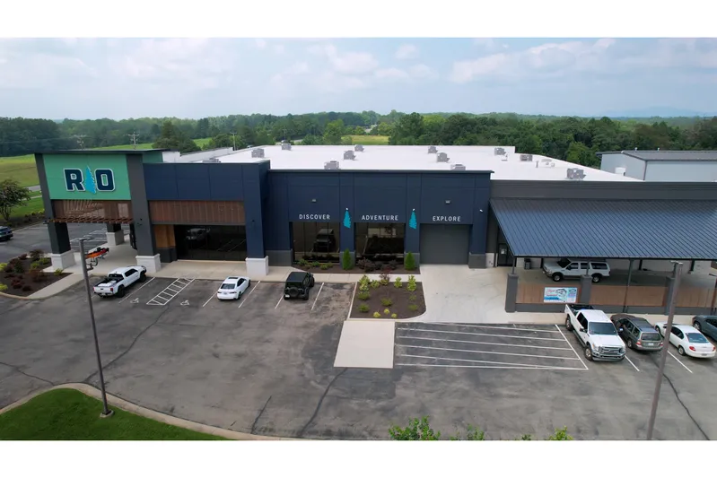  Yacht Photos Pics Aerial view of a modern building with parking, surrounded by greenery.