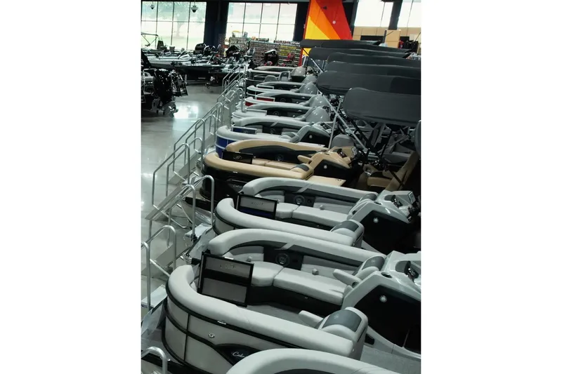  Yacht Photos Pics Indoor showroom displaying 2026 Barletta Lusso 23UCA pontoon boats in various colors.