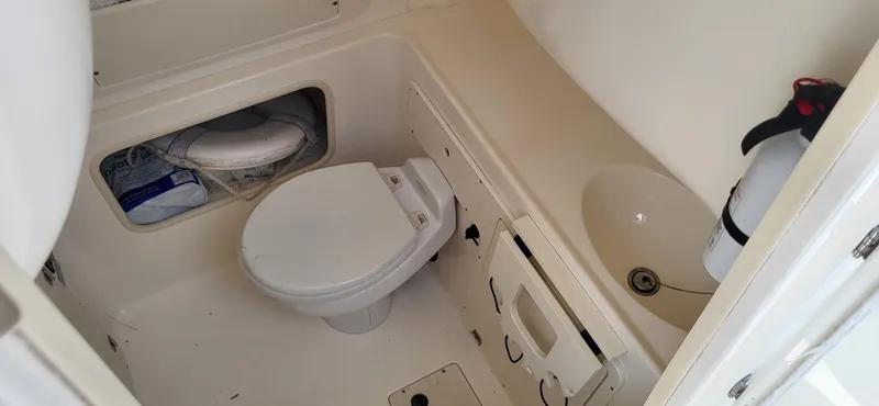  Yacht Photos Pics 2004 Boston Whaler 320 Outrage boat bathroom with toilet, sink, and fire extinguisher.