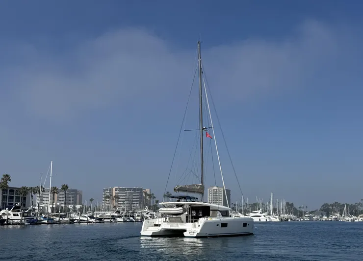 Catalina Breeze Yacht Photos Pics 2022 Lagoon 42 catamaran sailing in a marina with clear blue skies.