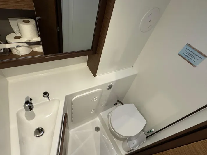 Catalina Breeze Yacht Photos Pics Bathroom interior of 2022 Lagoon 42 yacht with sink, toilet, and storage shelves.