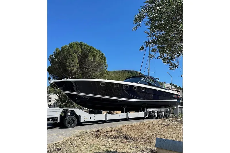  Yacht Photos Pics 1998 Otam Cigarette 45 Heritage yacht on trailer, surrounded by trees and clear blue sky.