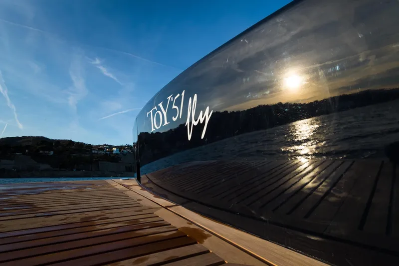 51 Fly Yacht Photos Pics Sleek Toy 51 Fly yacht reflecting sunset on water, 2025 model.