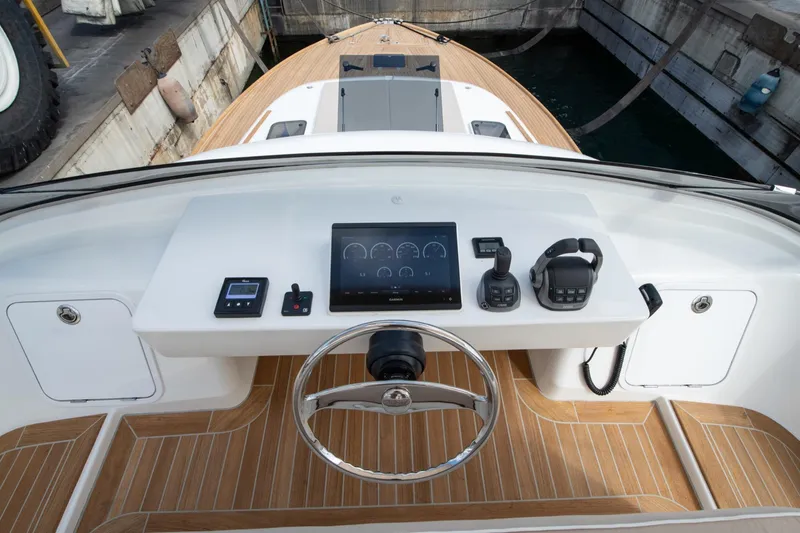 51 Fly Yacht Photos Pics Steering console of 2025 Toy 51 Fly yacht with modern controls and wooden deck.