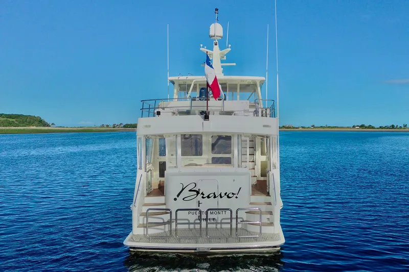 Bravo! Yacht Photos Pics 2012 Outer Reef Yachts 700 Motoryacht on calm water, rear view with clear sky.