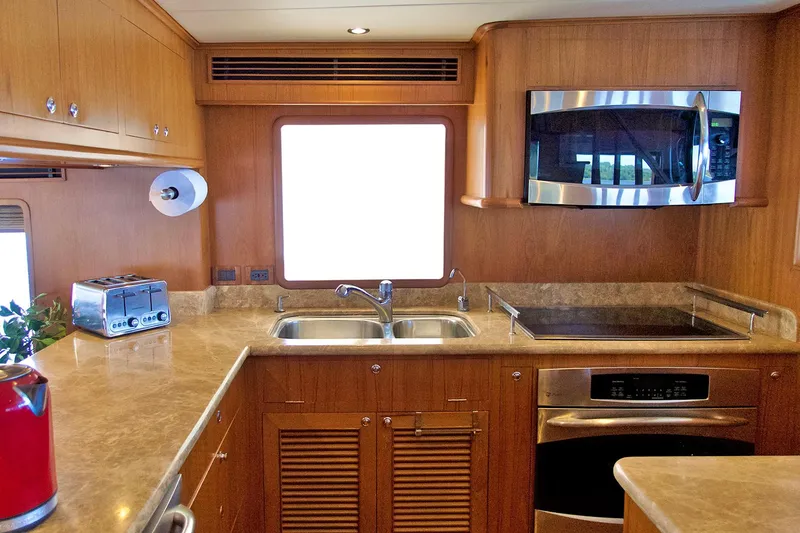 Bravo! Yacht Photos Pics Luxurious kitchen in 2012 Outer Reef Yachts 700 Motoryacht with modern appliances and wood cabinetry.