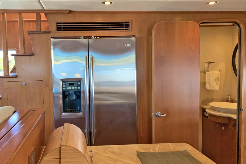 Bravo! Yacht Photos Pics Interior of 2012 Outer Reef Yachts 700 Motoryacht with stainless steel fridge and wooden cabinetry.