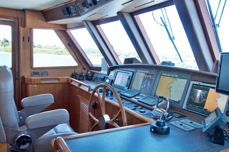 Bravo! Yacht Photos Pics Pilothouse of 2012 Outer Reef Yachts 700 Motoryacht with navigation equipment and wooden steering wheel.