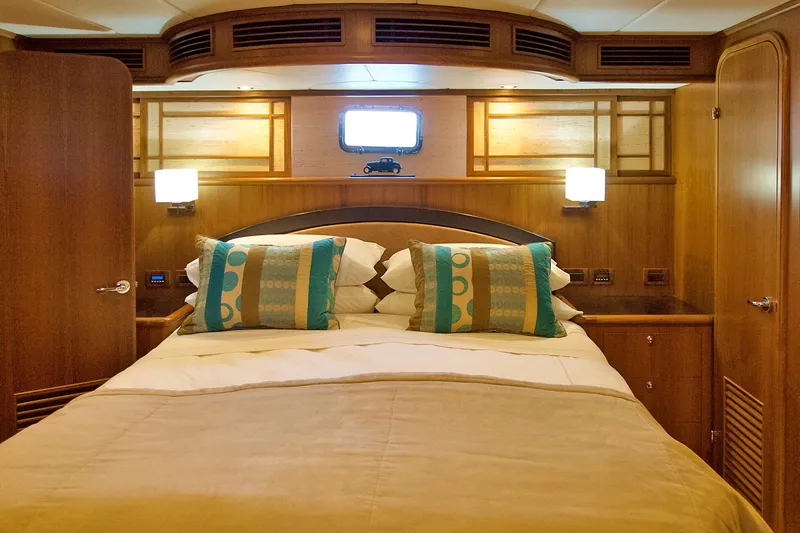 Bravo! Yacht Photos Pics Luxurious bedroom interior of 2012 Outer Reef Yachts 700 Motoryacht with elegant wood finish.