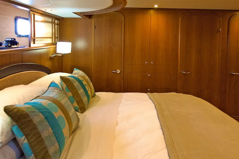 Bravo! Yacht Photos Pics Luxurious bedroom interior of 2012 Outer Reef Yachts 700 Motoryacht with elegant wood paneling.