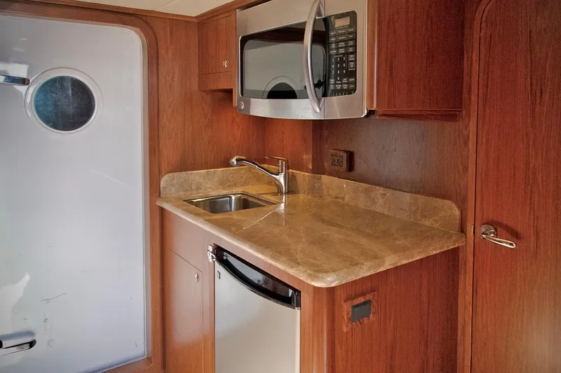 Bravo! Yacht Photos Pics Compact kitchen area in 2012 Outer Reef Yachts 700 Motoryacht with sink, microwave, and mini-fridge.