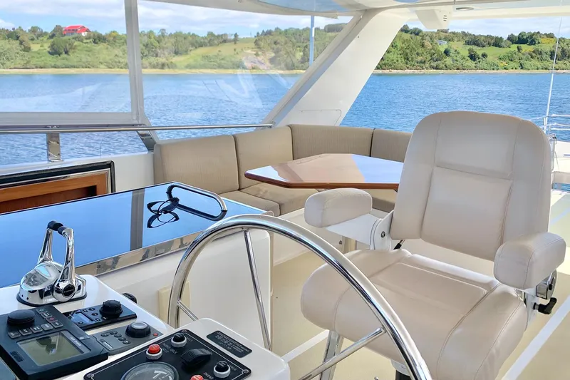 Bravo! Yacht Photos Pics Luxurious 2012 Outer Reef Yachts 700 Motoryacht helm with plush seating and scenic water view.