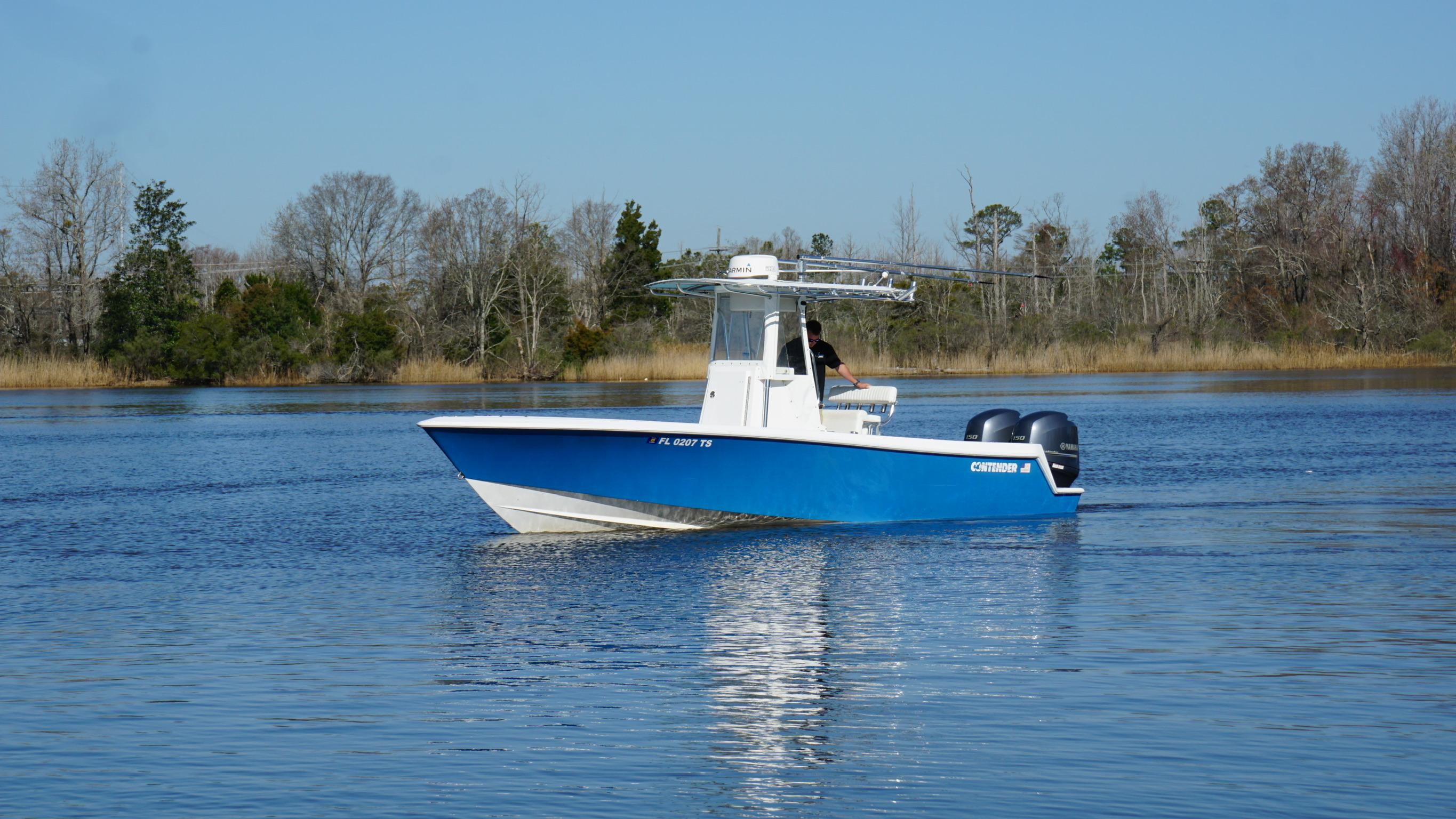 2015 Contender 25 Tournament boat on calm water, surrounded by trees.
